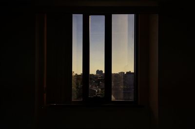 Silhouette buildings seen through window