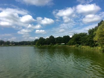 View of calm lake against cloudy sky