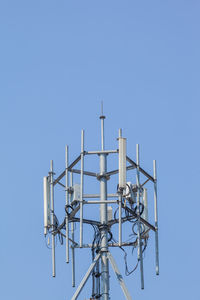 Low angle view of communications tower against clear blue sky