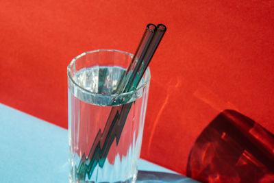 Reusable glass straws in glass with water on colorful background eco-friendly drinking straw set