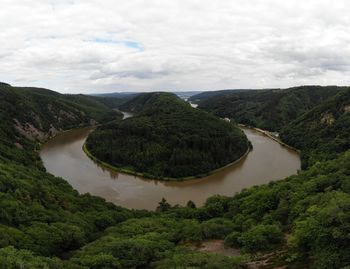 Scenic view of river amidst trees against sky