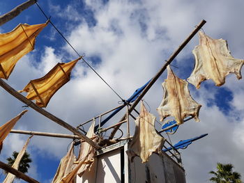 Low angle view of clothes hanging on against sky