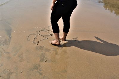 Low section of man standing on beach