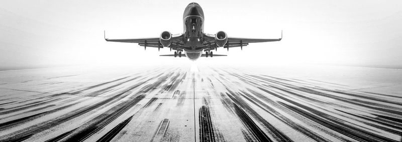 Low angle view of airplane flying against clear sky