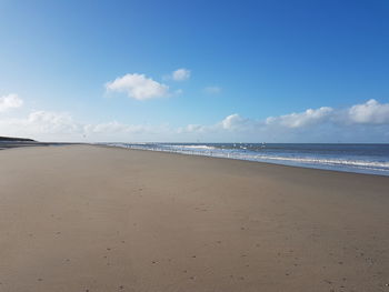 Scenic view of beach against blue sky