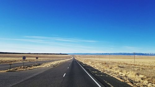 Road against clear blue sky