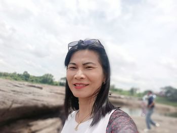 Portrait of smiling woman against sky