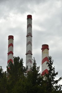 Low angle view of factory chimneys against sky