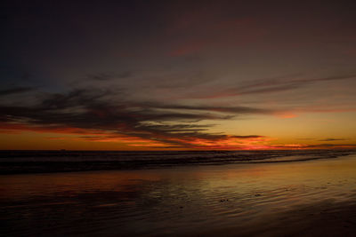 Scenic view of sea against dramatic sky during sunset