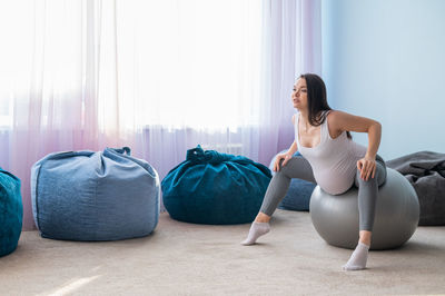 Full length of woman exercising in gym