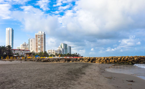 City at beach against sky