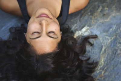 Portrait of a young woman asleep on a rock. she is young and beautiful.