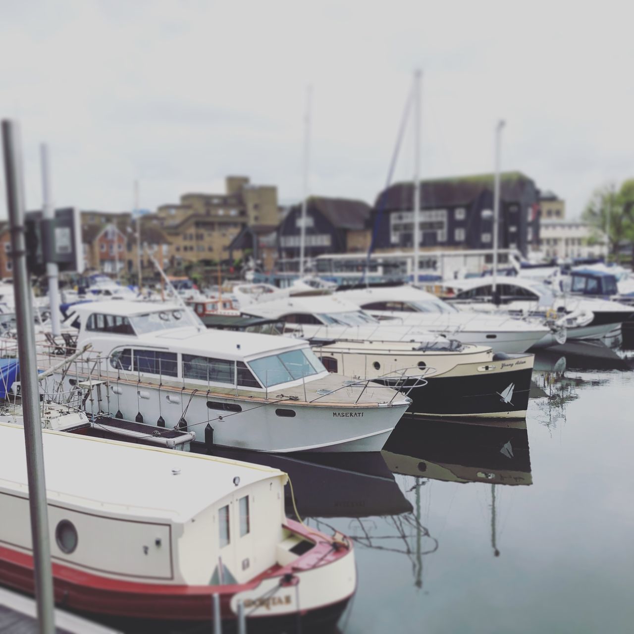 SAILBOATS MOORED AT HARBOR