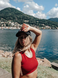 Young woman standing at beach against mountain