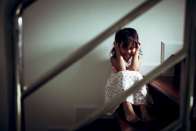 Girl screaming while sitting on staircase