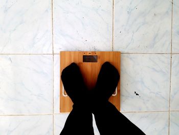 Low section of woman standing on tiled floor