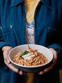 Midsection of woman holding indonesian noodle