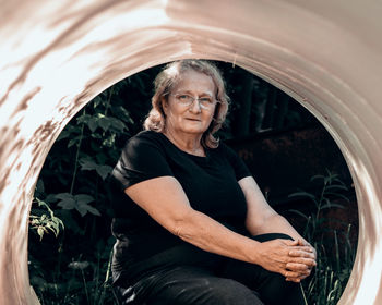 Portrait of elderly woman in glasses close-up on natural background. sunset light on face of senior