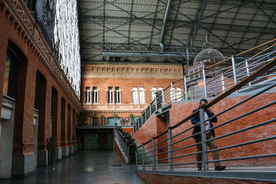 A man walking up the inclined pathway in madrid atocha train station