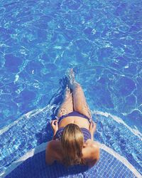 High angle view of young woman sitting in pool