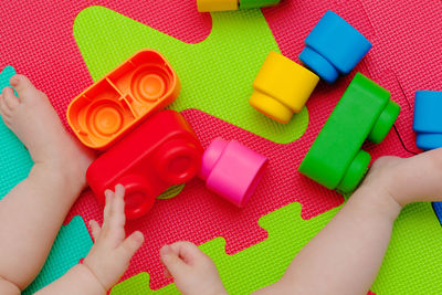 Low section of baby girl playing with toys at home