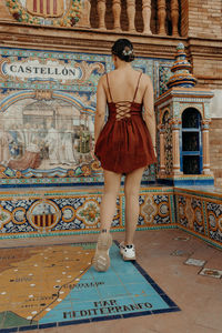 Full length of young woman standing on steps