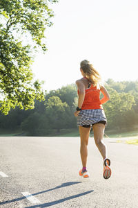 Woman jogging through country road