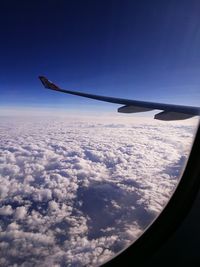 Aerial view of airplane wing against cloudy sky