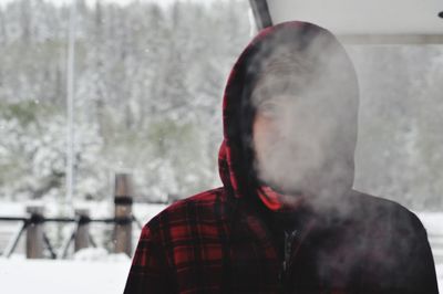 Man exhaling smoke during winter