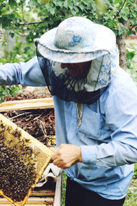 Beekeeper holding beehive