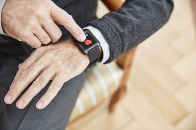 Senior man checking medical data on smartwatch