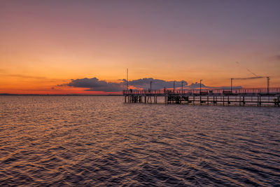 Pier over sea against sky during sunset