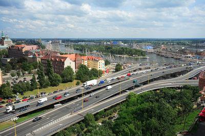 High angle view of vehicles on highway in city against sky