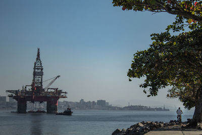 Offshore platform in sea against clear sky