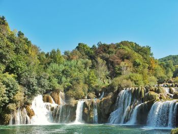 Scenic view of waterfall against clear sky