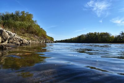 Scenic view of river against blue sky