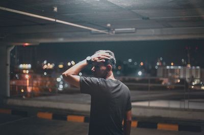 Man standing in city at night