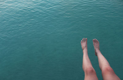 Low section of woman relaxing in swimming pool