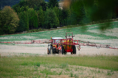 Agricultural equipment on a field, red tractor