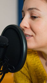 Close-up portrait of woman with digital camera