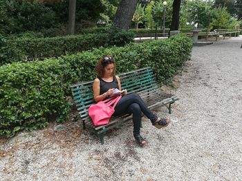 Woman sitting on seat in park