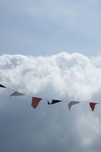 Low angle view of flags hanging against sky