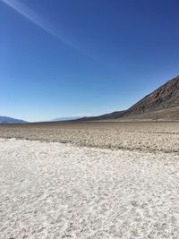 Scenic view of desert against clear blue sky