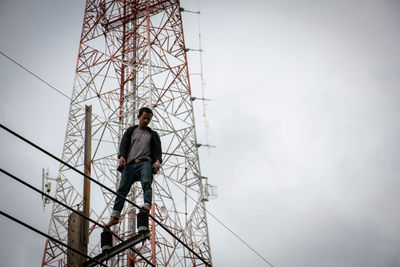 Low angle view of man working against sky