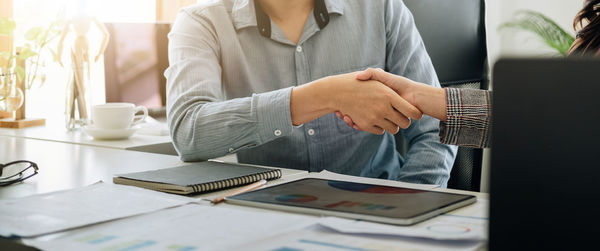 Midsection of businessman working at desk in office