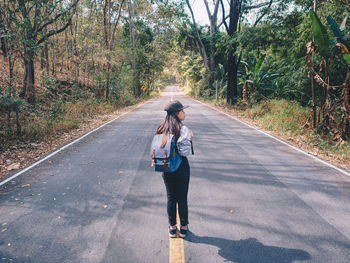 Rear view of man walking on road