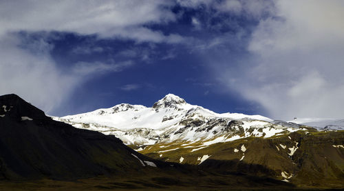 Scenic view of snowcapped mountain against cloudy sky