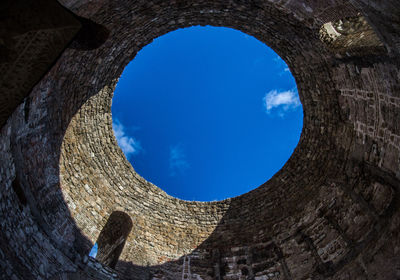 Low angle view of blue sky seen through hole