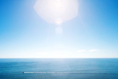 Scenic view of sea against blue sky on sunny day
