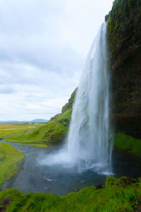 Scenic view of waterfall against sky